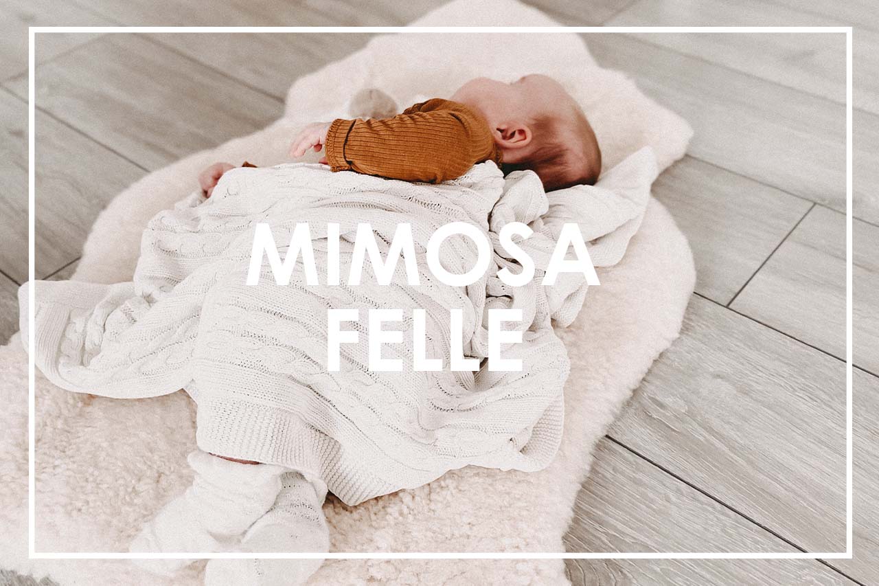 Baby mit Decke auf Mimosa Fell